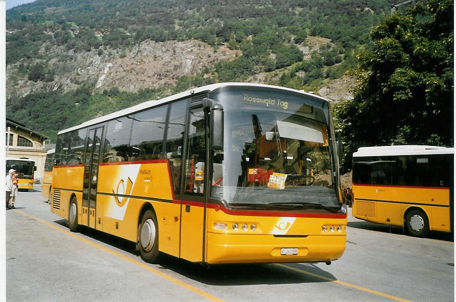 (069'801) - PostAuto Oberwallis - VS 243'896 - Neoplan (ex P 25'172) am 31. Juli 2004 beim Bahnhof Brig