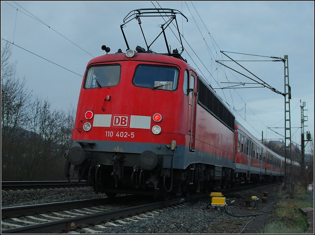 RB 30 mit 110 402-5 kurz vor Marburg. Das Fotopl�tzchen wurde erst vor einigen Monaten eingerichtet und ist nun ein �ffentlicher Parkplatz f�r Park-and-Ride lediglich durch eine Reihe Holzschwellen abgetrennt von der Bahn. An dieser Stelle waren fr�her die Gleise der Marburger Kreisbahn.