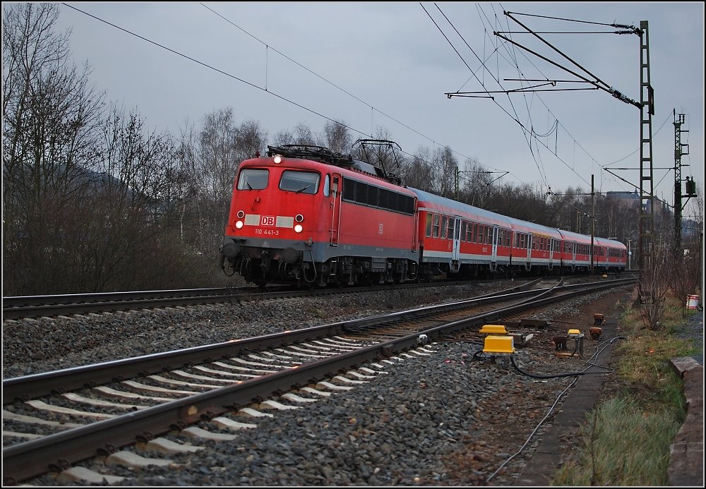 RB 30 mit 110 441-3 bei der Ausfahrt aus Marburg. Das Fotopl�tzchen wurde erst vor einigen Monaten eingerichtet und ist nun ein �ffentlicher Parkplatz f�r Park-and-Ride lediglich durch eine Reihe Holzschwellen abgetrennt von der Bahn. An dieser Stelle waren fr�her die Gleise der Marburger Kreisbahn.