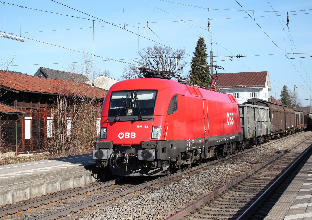 1116 133-8 durchfhrt am 9. April 2015 mit einem Gterzug den Bahnhof von Prien am Chiemsee.