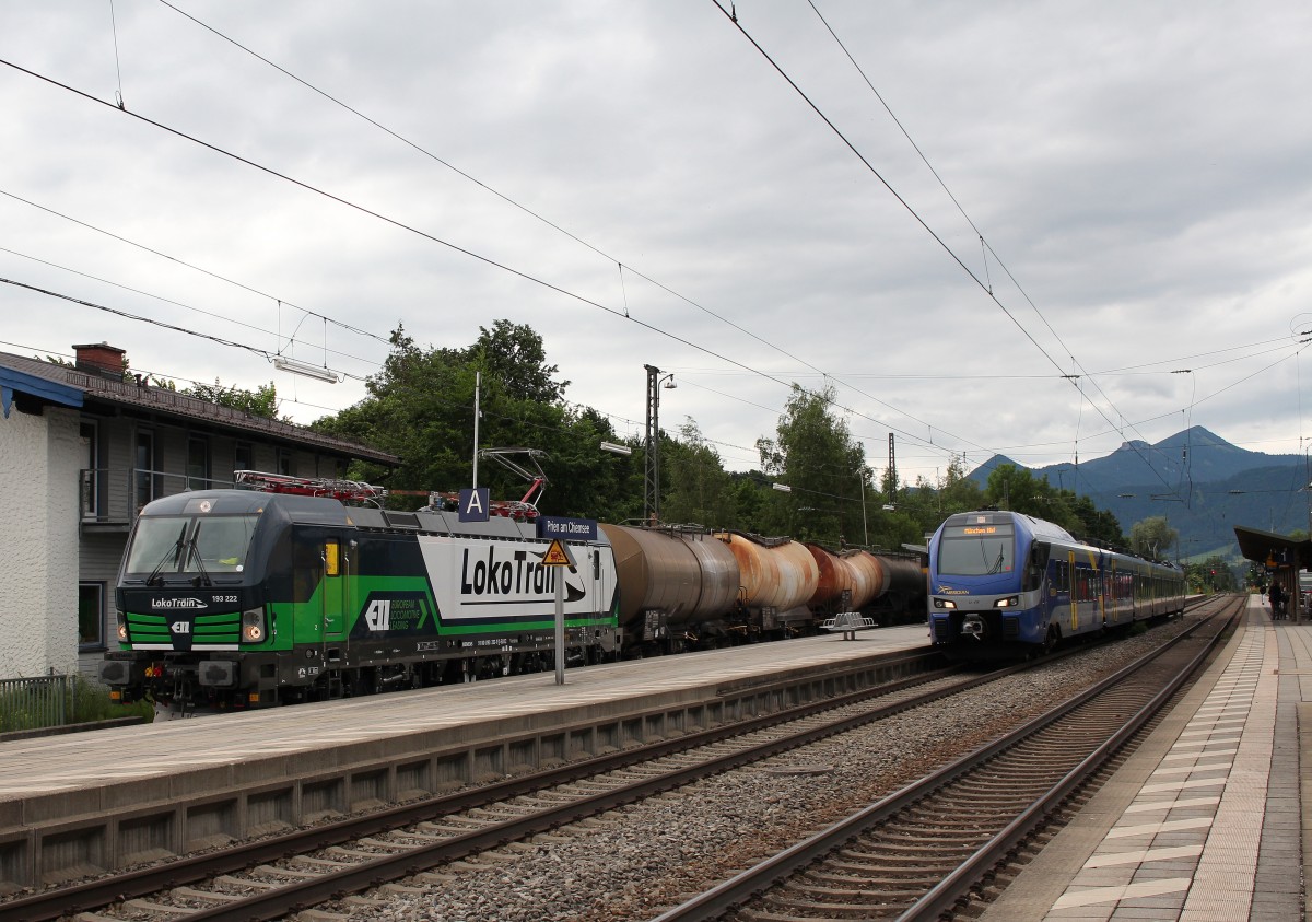 193 222 mit einem Kesselwagenzug muss am 8. Juni 2015 im Bahnhof von Prien am Chiemsee einen  Meridian -Regionalzug vorbeifahren lassen.