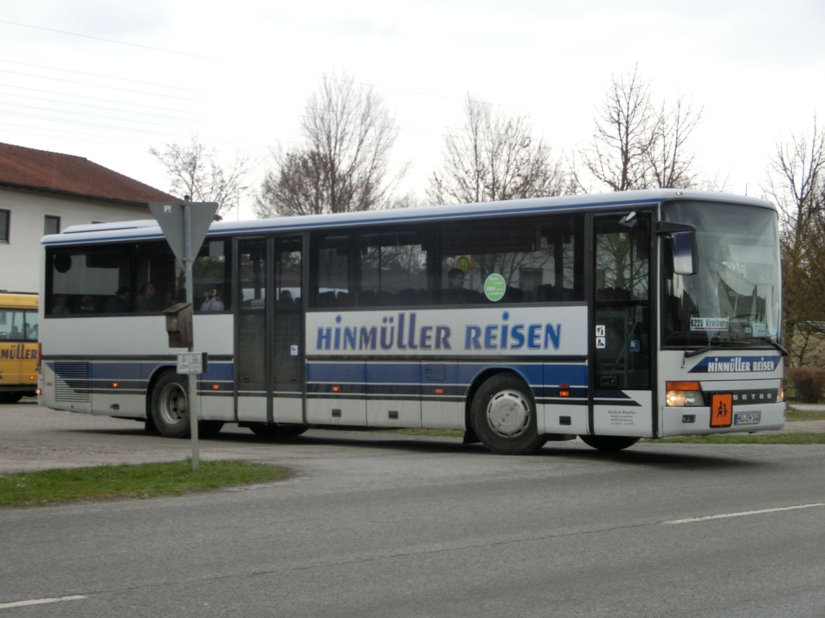 Setra S 315 UL von Hinmüller Reisen aus Oberflossing bei Polling. Er ist eines von mehreren Fahrzeugen dieses Typs, die die RBA Anfang 1996 in ihre Flotte aufnahm - dieses Exemplar lief damals unter dem Kennzeichen A-RV 103. In ihm ist die übliche Linienausstattung vorzufinden: Matrix-Zielanzeige, Fahrerkabine und die Setra-Überlandbestuhlung 'SC'. Da auch der Kinderwagenstellplatz nachträglich mit Sitzen versehen wurde, hat der Bus 53 Sitzplätze. Als Antrieb dient der MB OM 447 hLA mit 184 kW (250 PS) und das ZF-Sechsgang-Schaltgetriebe S 6-85.
Inzwischen trägt das Fahrzeug einen dunkelroten Lack.
Dieses Foto wurde am Mittag des 27. 3. 2015 an der Wendeschleife vor der Inn-Apotheke in Kraiburg/Inn aufgenommen, als der Bus aus Waldkraiburg kommend auf der RBO-Linie 6224 Kurs 034 unterwegs war.