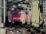 Die B�gelfalte 110 325-8 mit den blauen Farbhighlights verl�sst mit Bahntouristik-Wagen die Hohenzollernbr�cke und f�hrt in den Hauptbahnhof von K�ln ein.